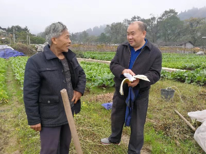 李端生老师在讲解张排村张社大道建设情况(钱小艳摄)