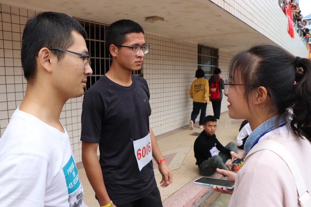图为 我院学通社社员采访跳远运动员(郭振华 摄)
